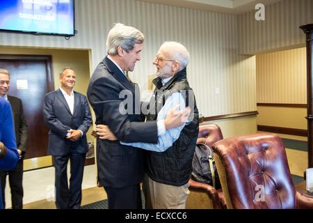 USAID Auftragnehmer Alan Gross, in Kuba für fünf Jahre inhaftiert wird von Außenminister John Kerry nach einem Flug von Kuba zurück begrüßt nach seiner Freilassung 17. Dezember 2014 auf Andrews Air Force Base in Maryland. Stockfoto