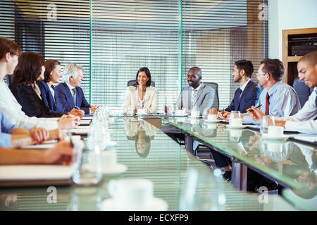 Geschäftsleute mit treffen im Konferenzraum, lächelnd und diskutieren Stockfoto