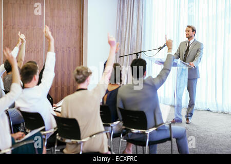 Personen am Seminar Hände erhebend, Fragen zu stellen Stockfoto