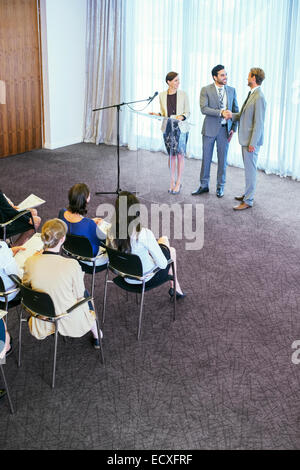 Redner, schütteln ihre Hände auf der Bühne während der Konferenz Stockfoto