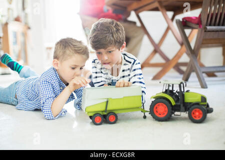 Brüder spielen mit Spielzeug-Traktor auf Etage Stockfoto