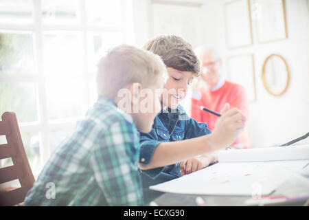 Jungen Zeichnung zusammen am Tisch Stockfoto