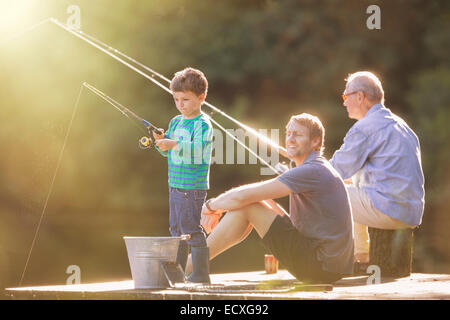 Junge, dock, Vater und Großvater Angeln auf Holz Stockfoto