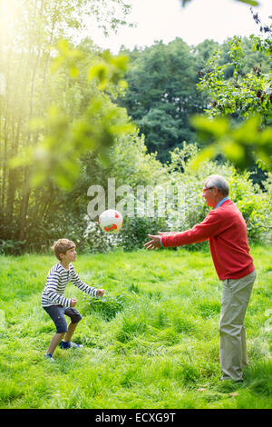 Großvater und Enkel Fußball spielen, Gras Stockfoto