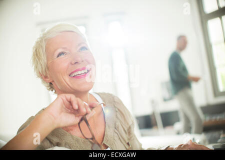 Ältere Frau lächelnd im Innenbereich Stockfoto