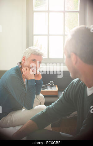 Männer, die gemeinsam im Wohnzimmer entspannen Stockfoto