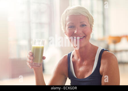 Ältere Frau trinken Saft lächelnd Stockfoto