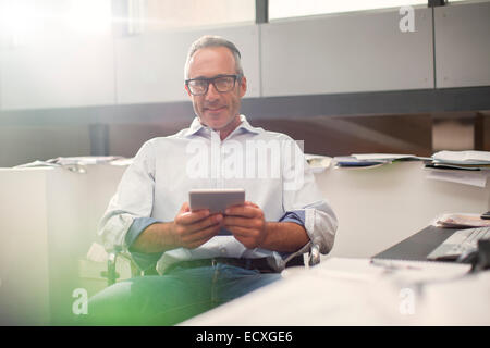 Geschäftsmann mit digital-Tablette am Schreibtisch Stockfoto