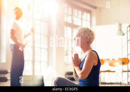 Ältere Frau, meditieren auf Etage Stockfoto