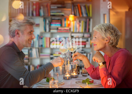 Älteres Ehepaar Toasten einander beim romantischen Abendessen Stockfoto