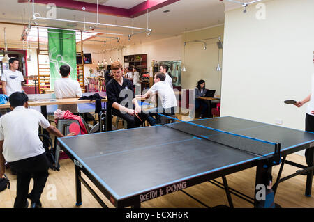 Jugendliche spielen Tischtennis und nach Schulclub an der "Wiff Waff Bar", ein Tischtennis / Pingpong Sport Spiele eingerichtete Cafébar, Aberystwyth Wales UK Stockfoto