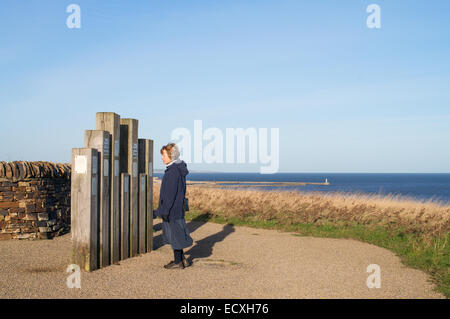 Frau liest Aushang an der Nase Punkt Seaham, County Durham, England, UK Stockfoto