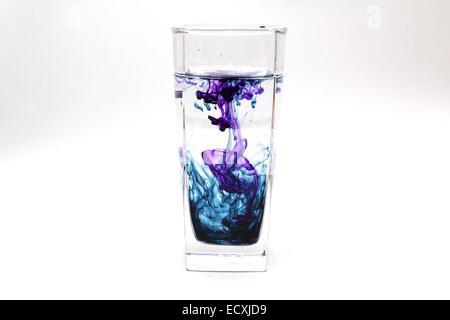 Transparentes Glas mit farbiger Tinte in Wasser Stockfoto