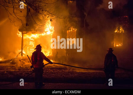 Detroit, Michigan USA - Feuerwehr Schlacht ein Feuer, das ein frei Haus in Detroit Morningside Nachbarschaft zerstört. Die Stadt hat Zehntausende von leerstehende Häuser durch Bevölkerung Verlust und Hypothek und Steuer Zwangsvollstreckungen. Bildnachweis: Jim West/Alamy Live-Nachrichten Stockfoto