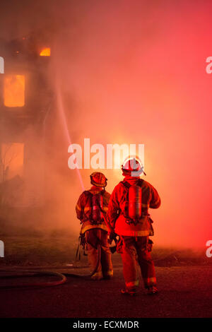 Detroit, Michigan USA - Feuerwehr Schlacht ein Feuer, das ein frei Haus in Detroit Morningside Nachbarschaft zerstört. Die Stadt hat Zehntausende von leerstehende Häuser durch Bevölkerung Verlust und Hypothek und Steuer Zwangsvollstreckungen. Bildnachweis: Jim West/Alamy Live-Nachrichten Stockfoto