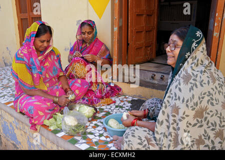 Frauen, die Zubereitung von Speisen vor Haus in die blaue Stadt Jodhpur, Rajasthan, Indien Stockfoto