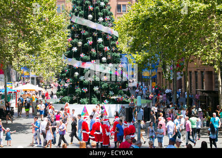 Sydney, Australien. 22. Dezember 2014. Während Sydneysiders lassen Sie Blumen in Martin Place weiterhin, beherbergt das westliche Ende der Fußgängerzone der Stadt Weihnachtsbaum und Versionen von Santa Claus. Bildnachweis: Martin Beere/Alamy Live News Stockfoto