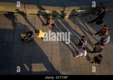 Die lange Schatten von fremden, wie sie entlang der Londoner Southbank Fuß. Stockfoto