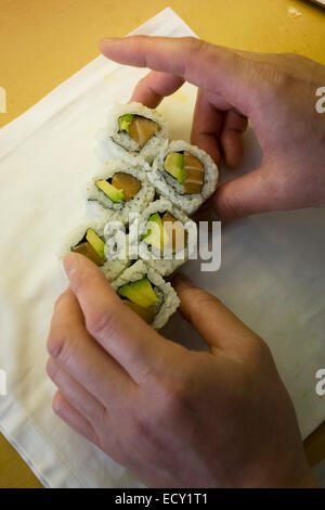 Detail des Küchenchefs Hände, vorbereitet Makizushi in "So", ein Sushi-Restaurant im Zentrum von London. Stockfoto