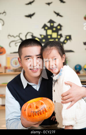 Kindergärtnerin und Mädchen Kürbis schnitzen Stockfoto