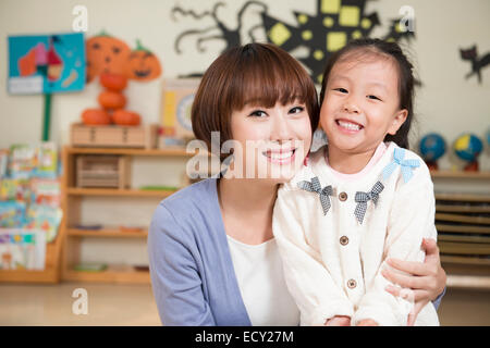 Kindergärtnerin und Mädchen Kürbis schnitzen Stockfoto