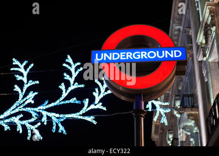 LONDON, UK - Dezember 20: Nachts Schuss von London underground Ortseingangsschild mit Weihnachtsbeleuchtung im Hintergrund. 2 Dezember Stockfoto