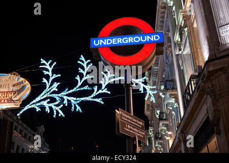 LONDON, UK - Dezember 20: Nachts Schuss von London underground Ortseingangsschild mit Weihnachtsbeleuchtung im Hintergrund. 2 Dezember Stockfoto