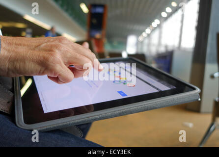 Person mit dem Ipad am Flughafen über kostenlose WiFi-Verbindung. Paris. Charles de Gaulle. Stockfoto