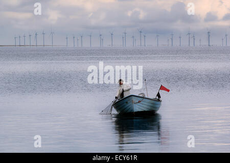 Mann Angeln in der Nordsee vor der schwedischen Küste mit einem Windpark im Hintergrund. Stockfoto