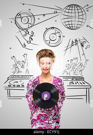 Bunte Foto von einem clubbing modischen Hippie-Deejay bei der Tanzparty eine Retro-Schallplatte in ihren Händen auf grauen sk hält Stockfoto