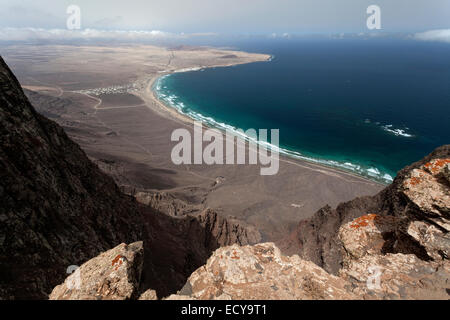 Blick vom Mirador del Bosquecillo, Risco de Famara, am Strand von Famara oder Playa de Famara mit La Calaeta und Famara resort Stockfoto