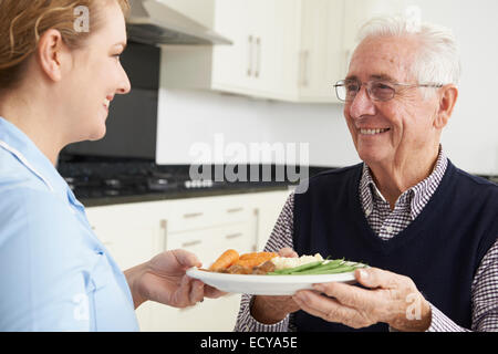 Pflegeperson das Mittagessen für den älteren Menschen Stockfoto