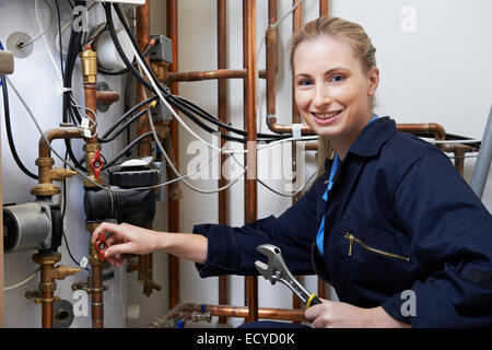 Weibliche Klempner Arbeiten an zentralen Heizkessel Stockfoto