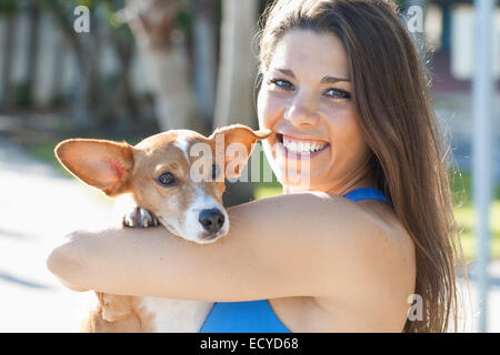 Kaukasische Frau Holding-Hund im freien Stockfoto