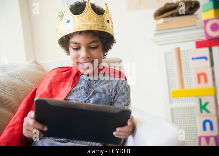 Gemischte Rassen junge im Kostüm mit digital-Tablette im Wohnzimmer Stockfoto