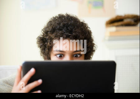 Gemischte Rassen junge mit digital-Tablette im Wohnzimmer Stockfoto