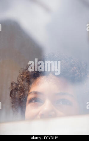 Gemischte Rassen junge Blick aus Fenster Stockfoto