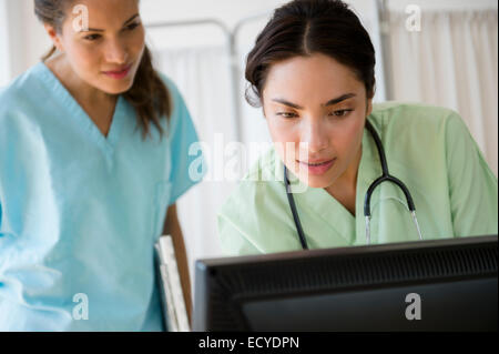 Hispanische Krankenschwestern arbeiten gemeinsam an Computer im Krankenhaus Stockfoto