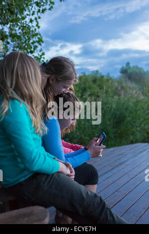 Kinder mit Handy zusammen im freien Stockfoto