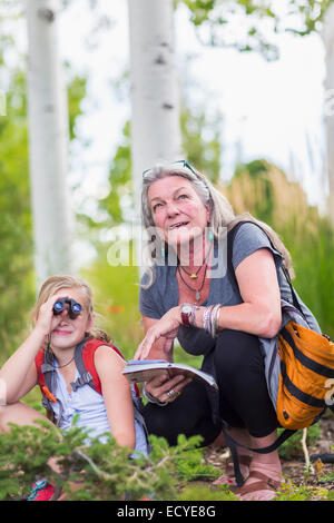 Kaukasische Großmutter und Enkelin mit dem Fernglas beim Wandern Stockfoto