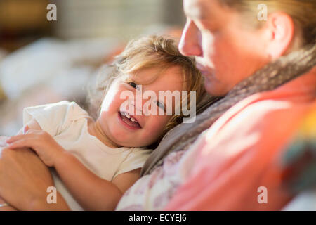 Kaukasische Mutter und Baby Sohn kuscheln auf dem Sofa Stockfoto