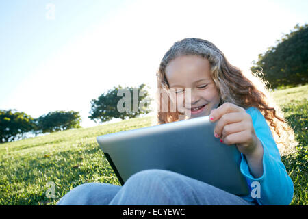 Gemischte Rassen Mädchen mit digital-Tablette in Feld Stockfoto