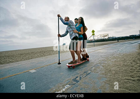 Skaten mit Freunden paddeln Pol am Strand Stockfoto