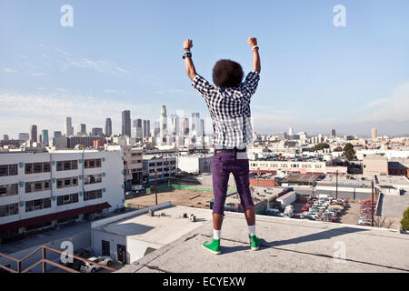 Afrikanische amerikanische Mann mit Blick auf Stadtbild von urbanen Dachterrasse Stockfoto