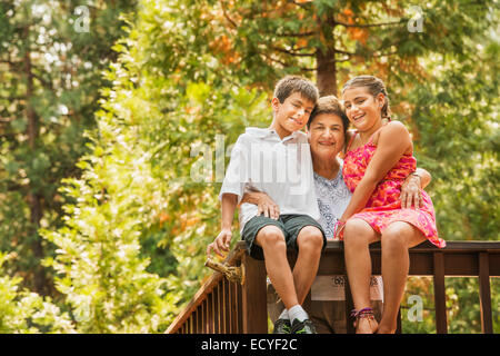 Großmutter und Enkel lächelnd auf Geländer Stockfoto