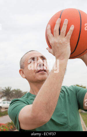 Hispanische senior woman spielen Basketball im freien Stockfoto