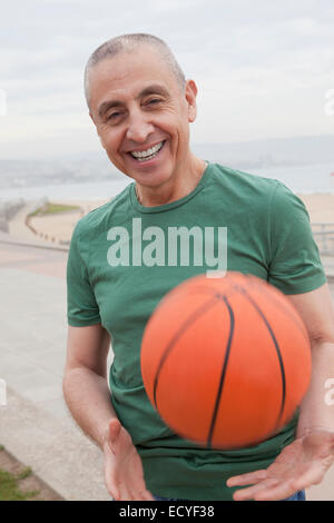 Hispanische senior woman spielen Basketball im freien Stockfoto