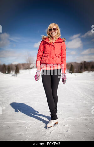 Kaukasische Frau auf Schlittschuhen auf zugefrorenen See Stockfoto