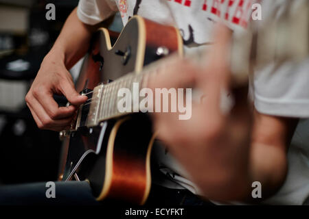 Nahaufnahme von kaukasischen Mann spielt Gitarre Stockfoto