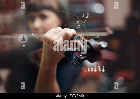 Kaukasische Frau Geigenspiel überlagert mit Grafik-design Stockfoto